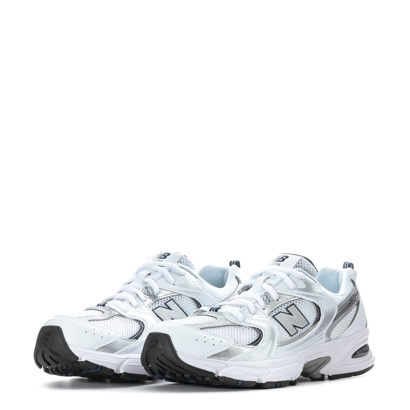 Pair of white youth sneakers with lace-up design, N logo, and black outsole