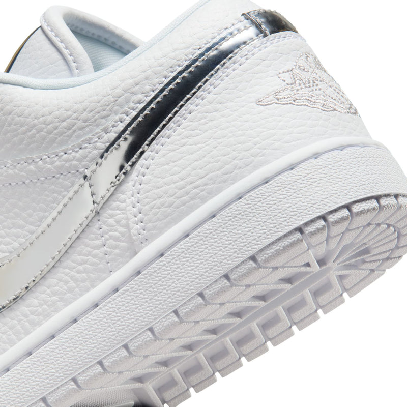 Women's white sneaker close-up of side panel with metallic silver Swoosh and outsole