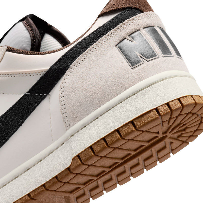 Close-up of Nike low-top sneaker side panel with textured sole and gum tread