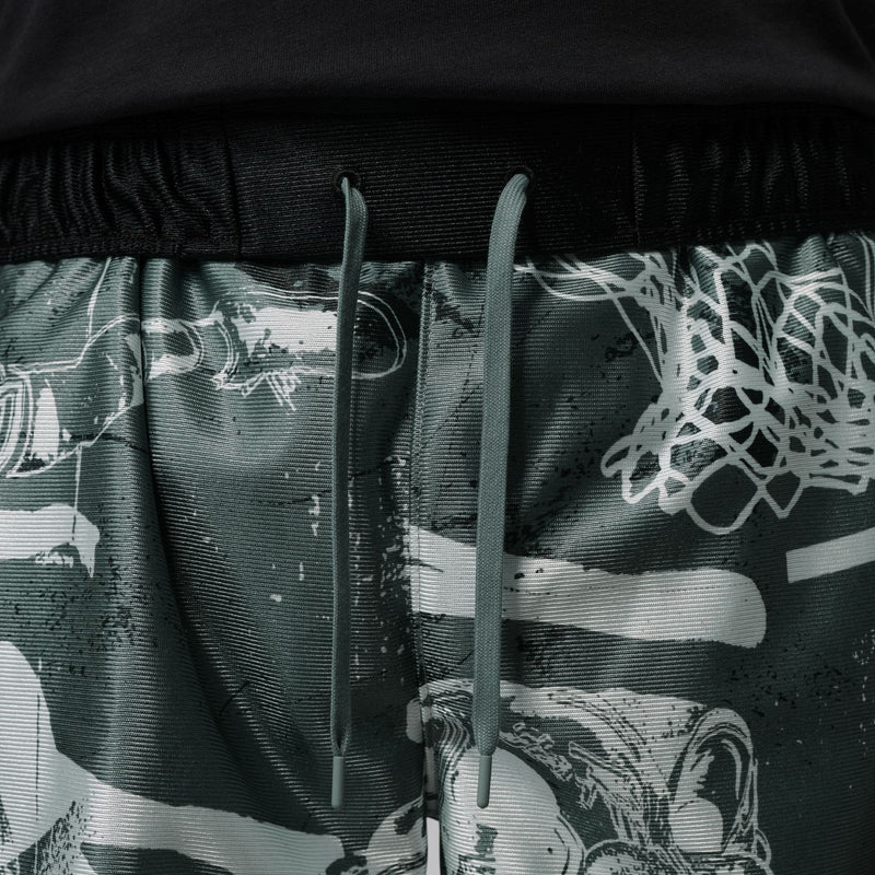 Black elastic waistband on dark green graphic shorts with white web-like print