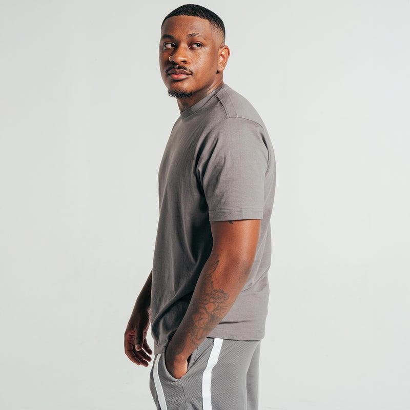 Castlerock gray crew neck T-shirt, short sleeves, side view with arm tattoos.