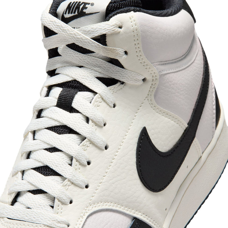 Men's mid-top sneaker close-up: off-white leather-look, black swoosh, white laces.