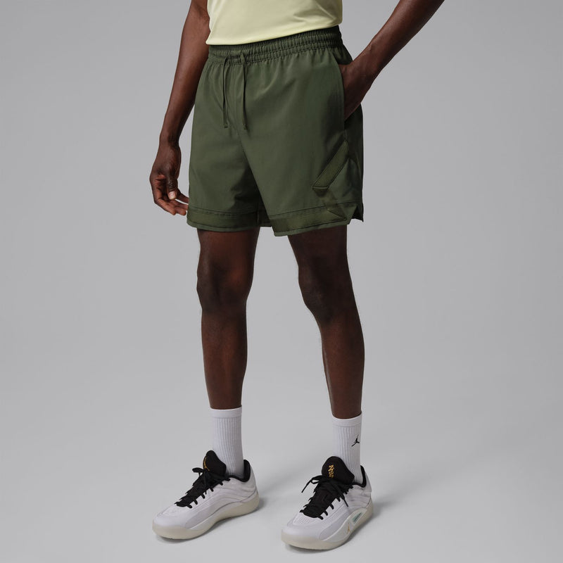 Men's olive woven cargo shorts from the side, elastic waistband and angled pocket panels