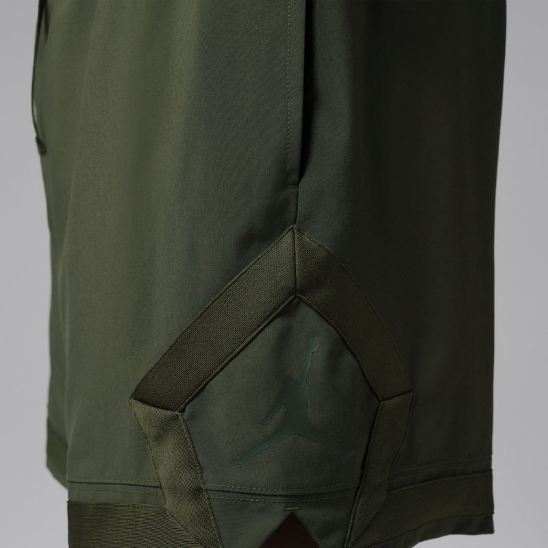 Close-up of olive woven cargo shorts side pocket with stitched seam detail