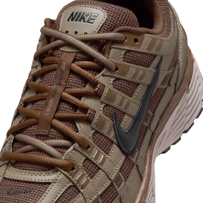 Men's brown sneaker upper close-up with lace eyelets and Nike Swoosh detail