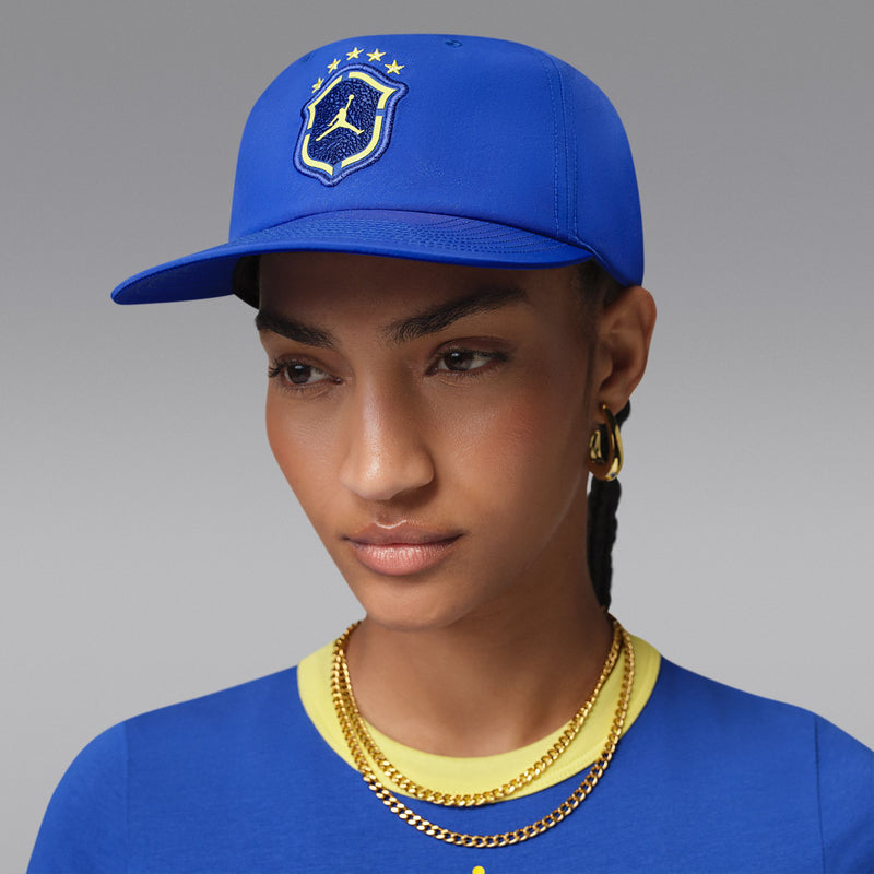 Royal blue snapback cap worn with yellow Jordan shield logo on the front