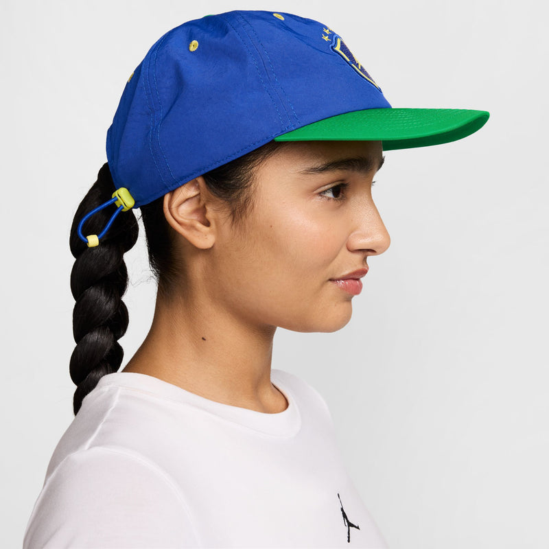 Royal blue snapback cap with green undervisor, side profile with Jordan logo
