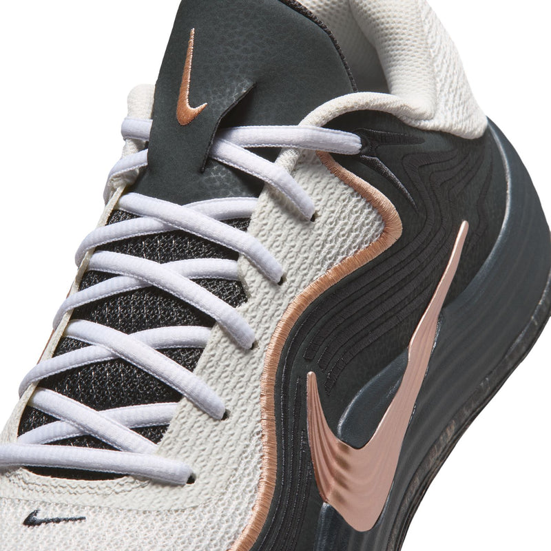 Men's low-top shoe close-up: white laces, black panel, rose-gold swoosh detail