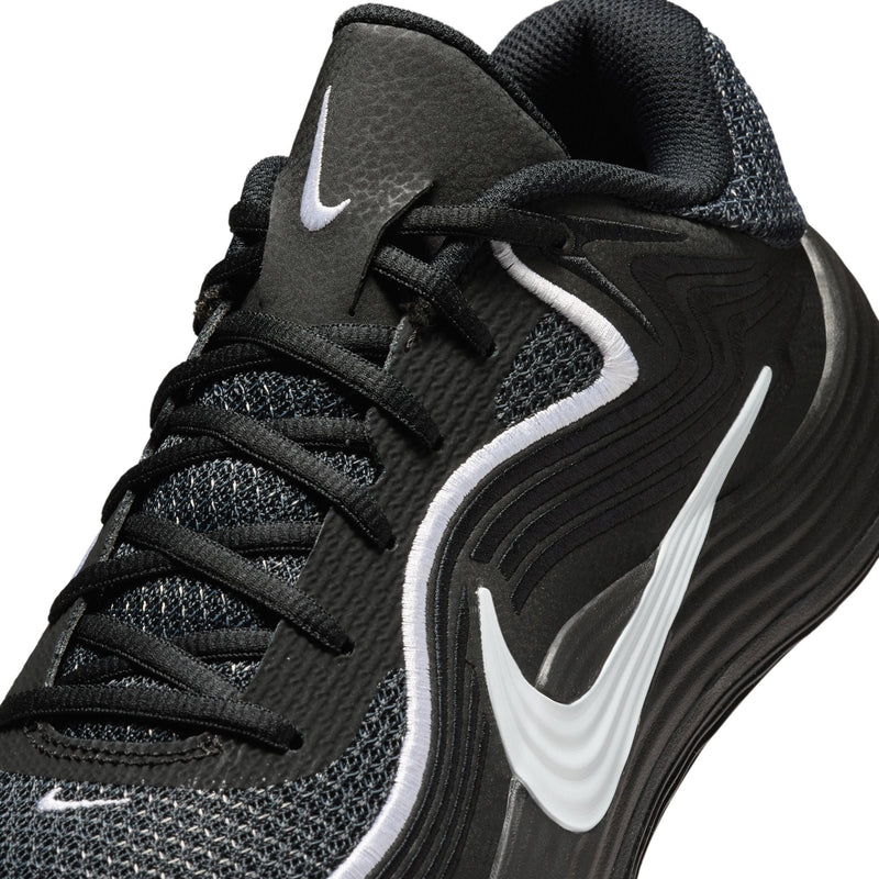 Men's black knit sneakers close-up with white swoosh and black laces