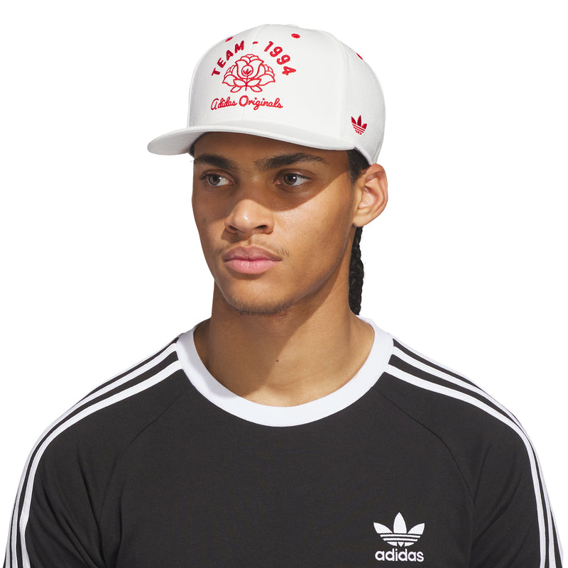 Off-white snapback cap worn by model with red TEAM-1994 logo