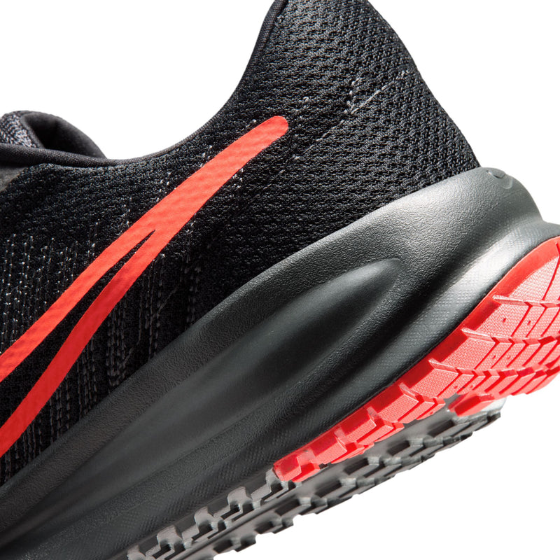 Men's black running shoe side close-up with crimson stripe and traction sole