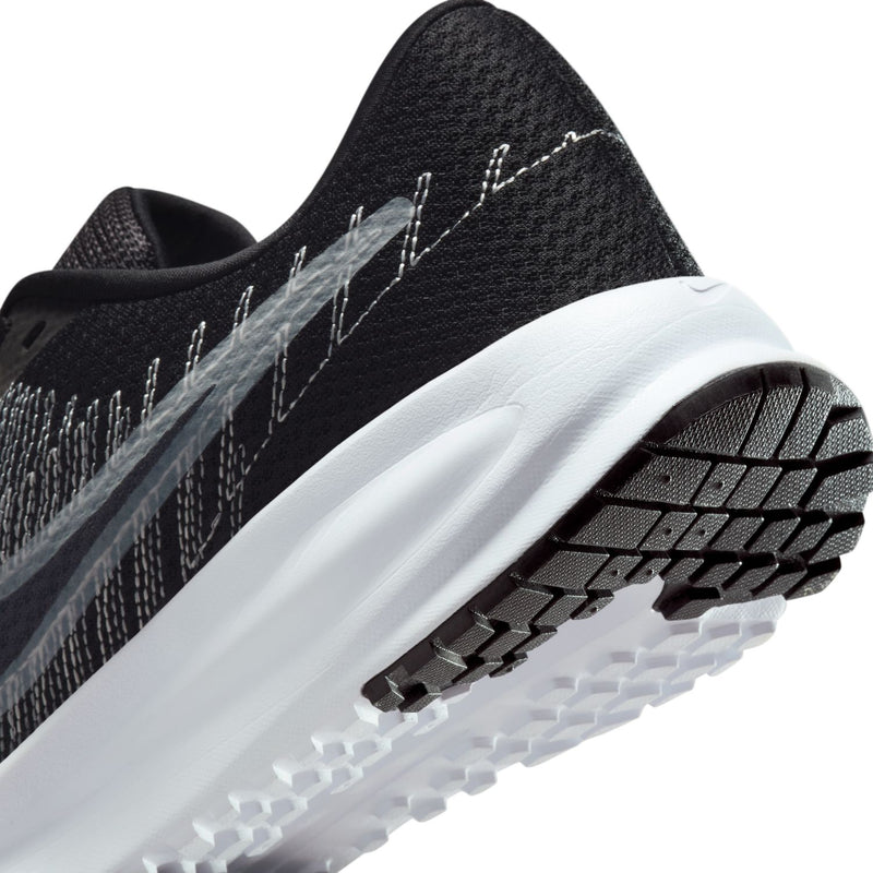 Women's running shoe side view with white midsole and black traction tread