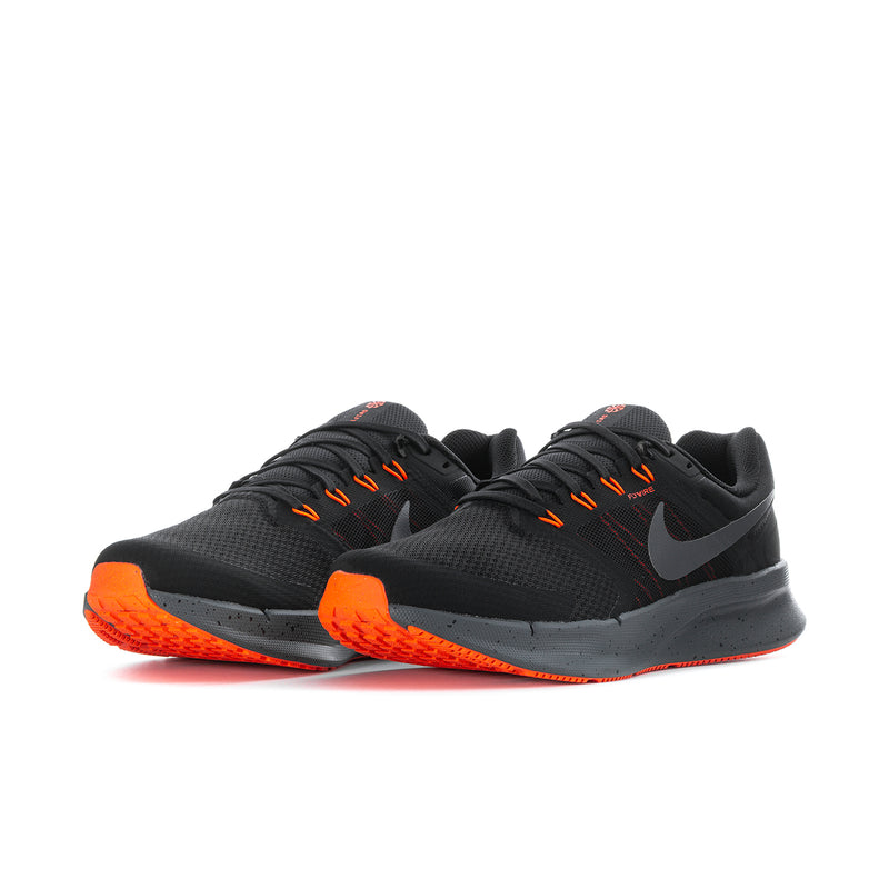 Pair of black knit running shoes with orange lace accents and side swoosh.