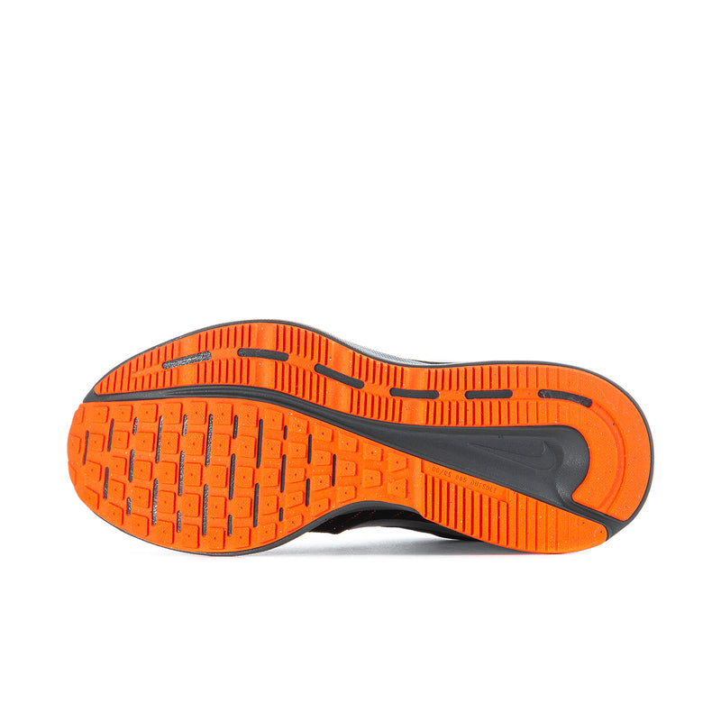 Orange-and-black rubber outsole with tread pattern on black running shoe.