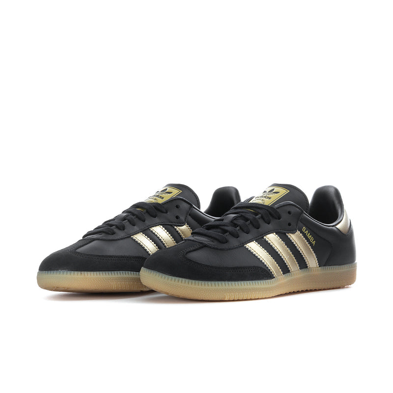 Samba OG women's sneakers angled front view, black leather with gold stripes and gum sole