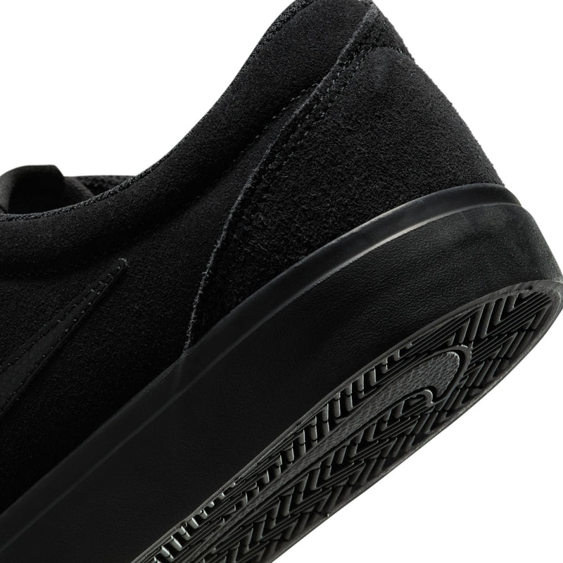 Close-up of black sneaker side and sole edge with textured outsole tread detail.