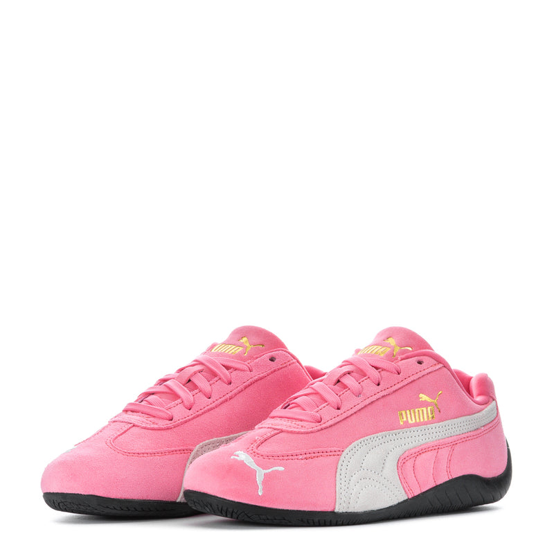 Pair of youth pink Puma sneakers with white side panels, black soles, and lace-up uppers.