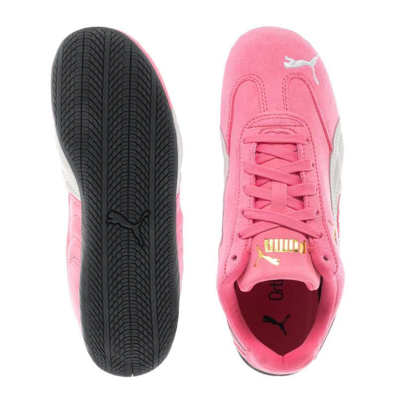 Pink youth Puma sneakers showing treaded black outsole and lace-up front with logo.