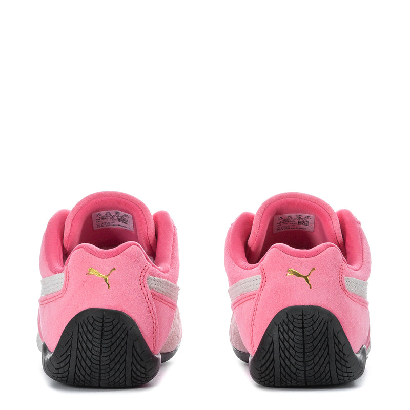 Back view of youth pink Puma sneakers with black heel tread, fabric upper and logo details.