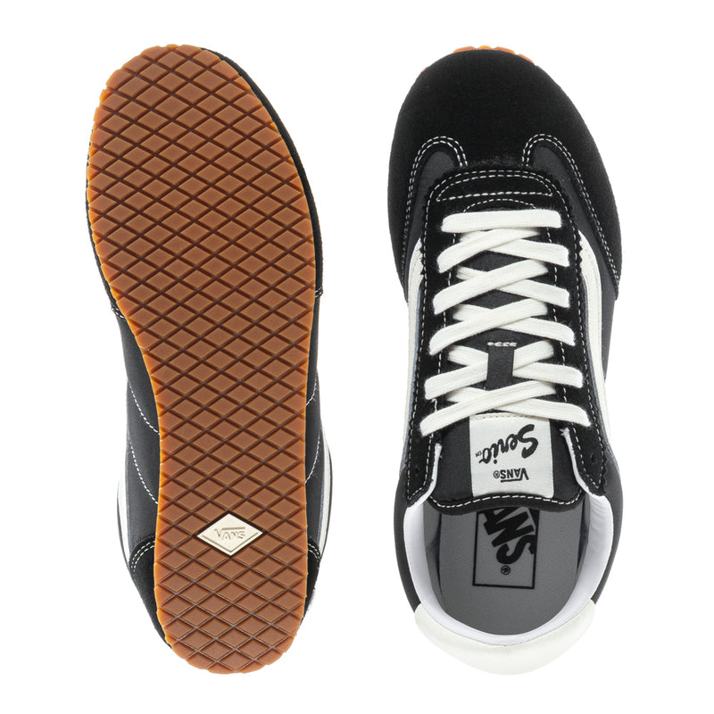 Women's low-top sneakers with outsole tread, black lace-up upper, gum rubber sole