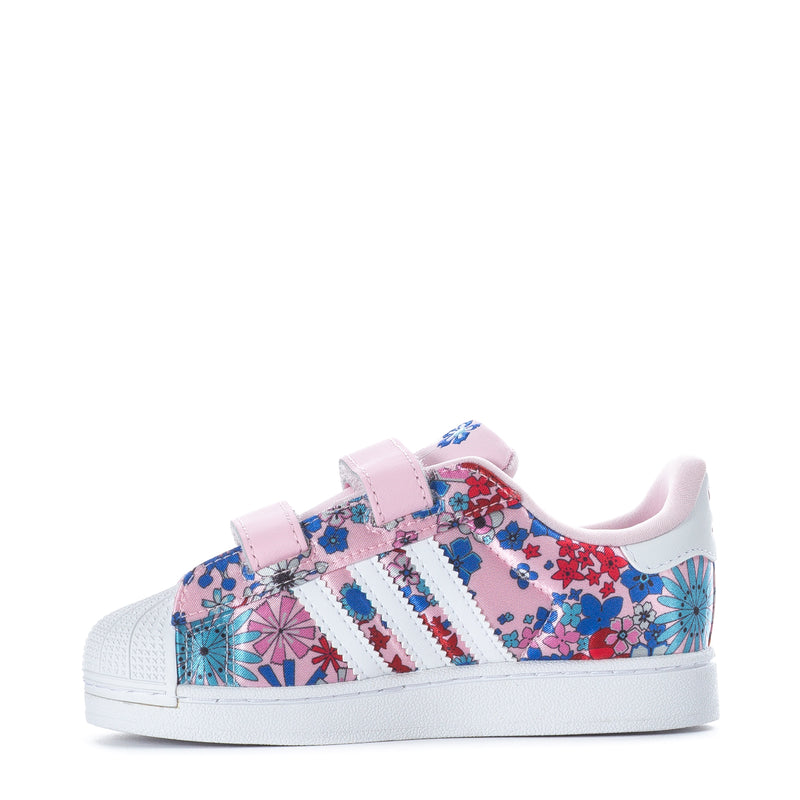 Toddler sneakers front view with pink strap and colorful floral upper with adidas stripes.