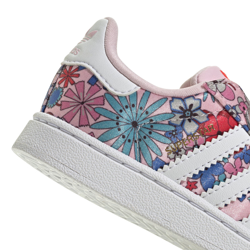 Toddler sneakers side view: floral patterned upper with white laces and pink accents.