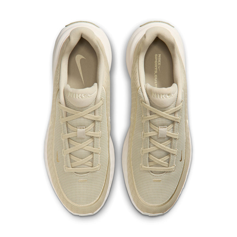 Pair of beige lace-up sneakers with Nike branding on tongue and white trim.