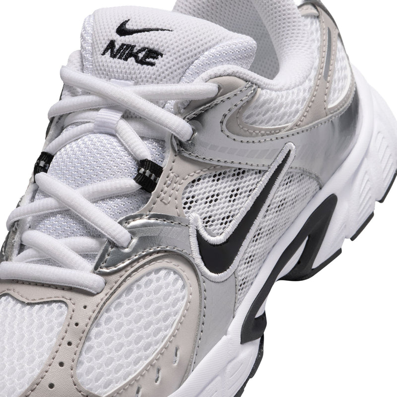 Close-up of youth sneaker upper: white and light gray mesh with black Nike swoosh