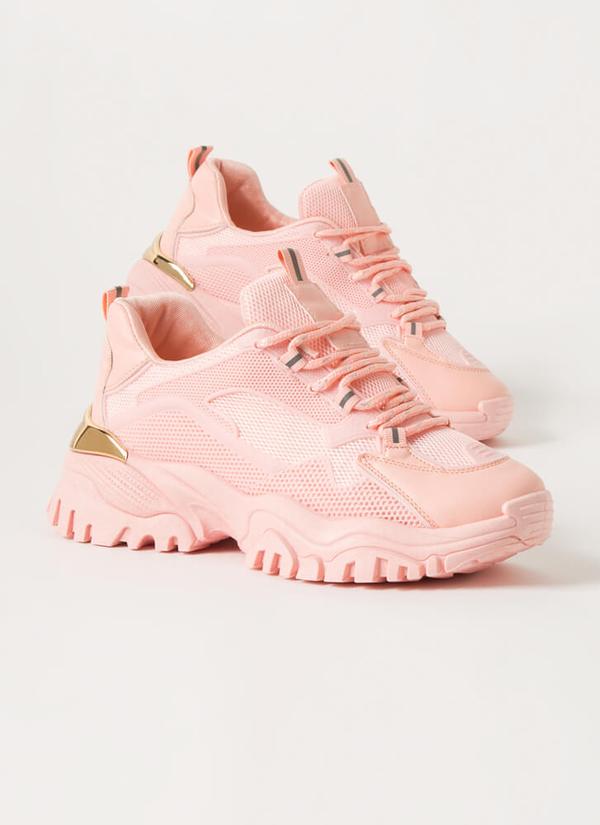 Pink sneakers with gold accents on a light gray background